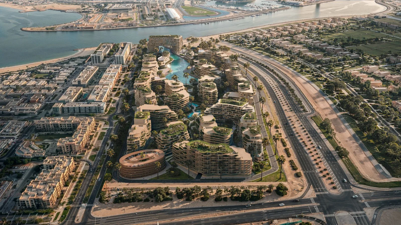 Daytime aerial of The Wadi community on the Yas Canal in Abu Dhabi, with organic building forms and a circular podium