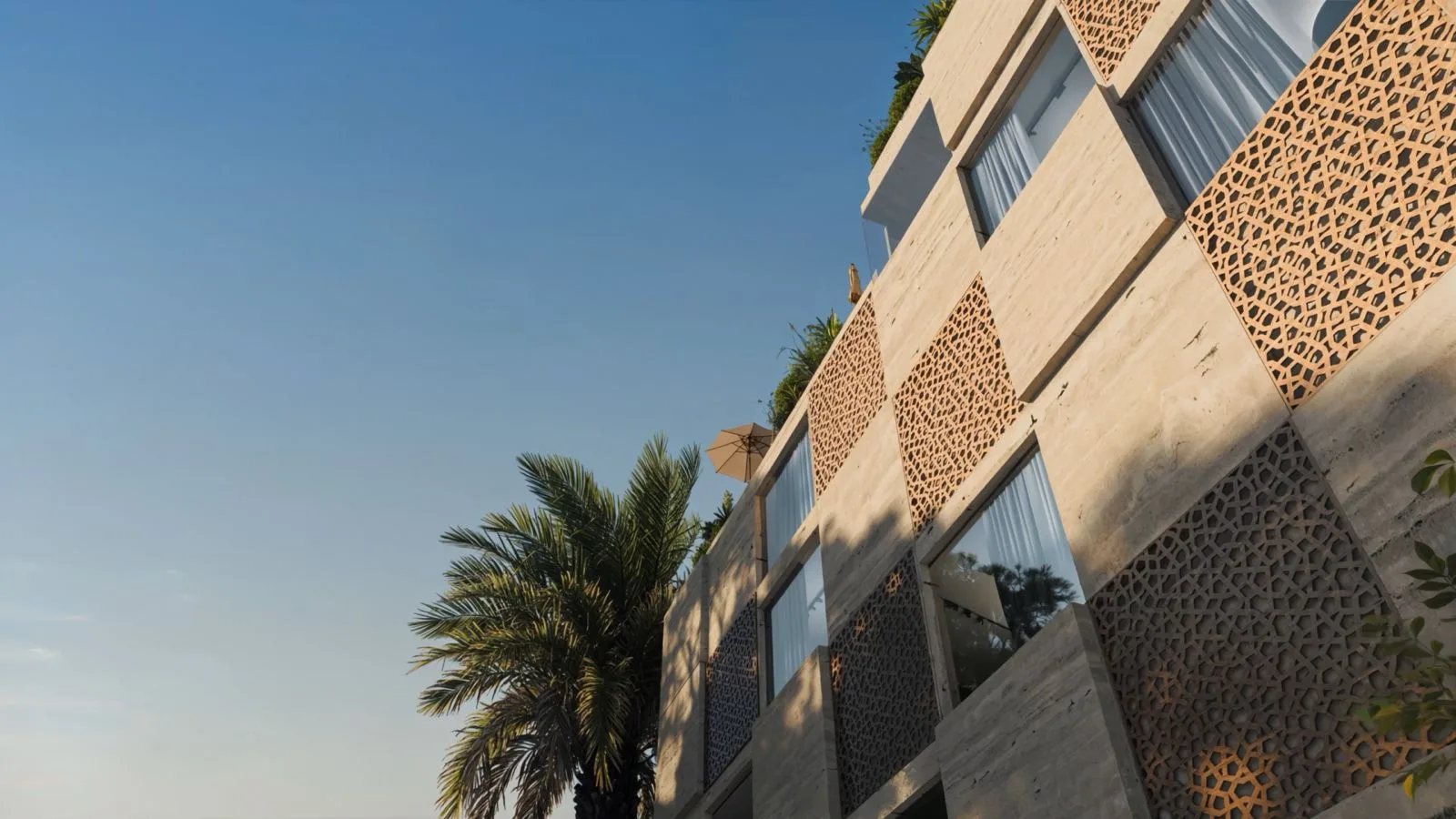 Facade detail at The Wadi on the Yas Canal in Abu Dhabi, with patterned screens, windows, and a palm