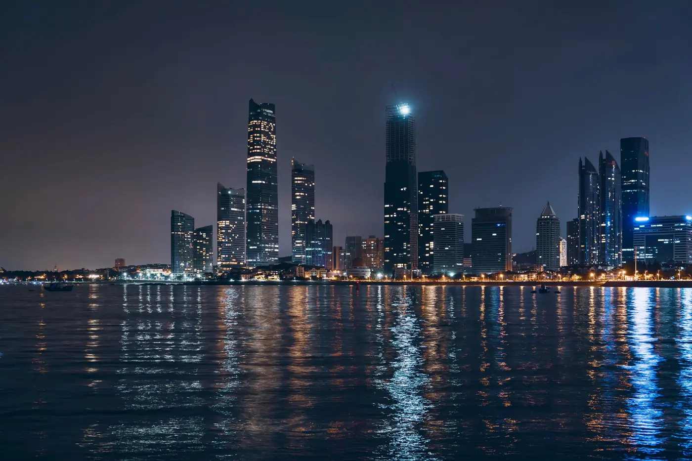 Abu Dhabi skyline reflected in the water at night, location photography for One&Only Private Residences Al Maryah Island