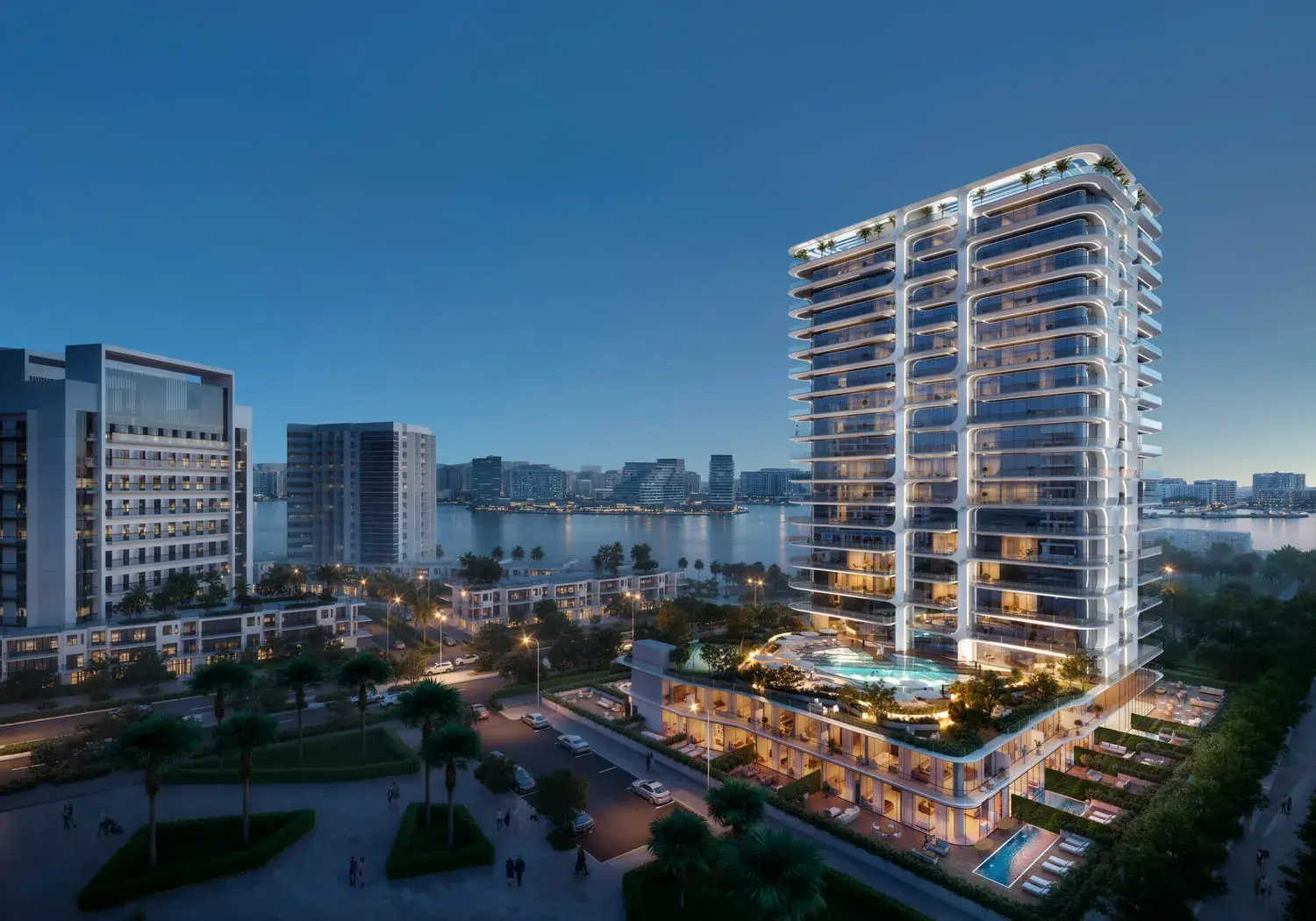 Stellar by Elie Saab residential tower illuminated at dusk beside landscaped public spaces on Yas Island, Abu Dhabi